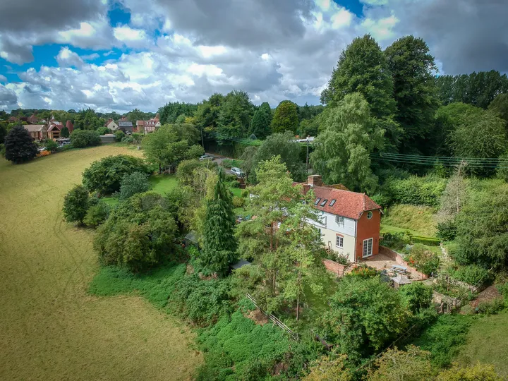 The cottage and garden from the air, with the village beyond